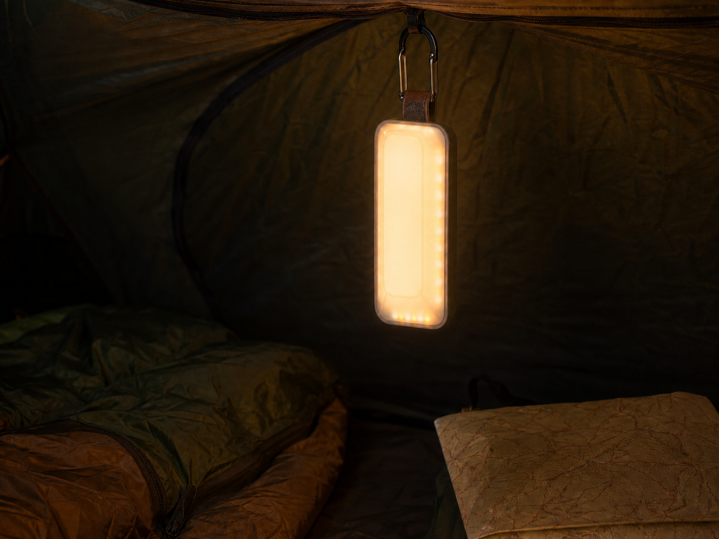 Khonsu E3 amber camping lantern hanging inside a tent at night